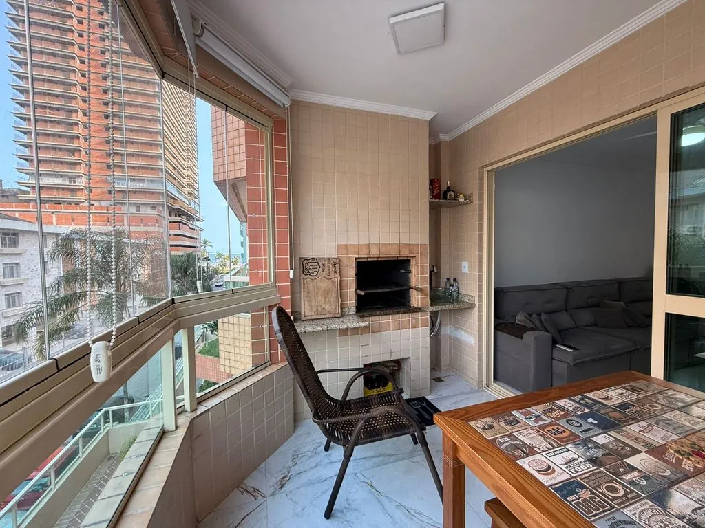 ampla varanda gourmet envidraçada com vista mar privilegiada, churrasqueira a carvão e cortina blackout