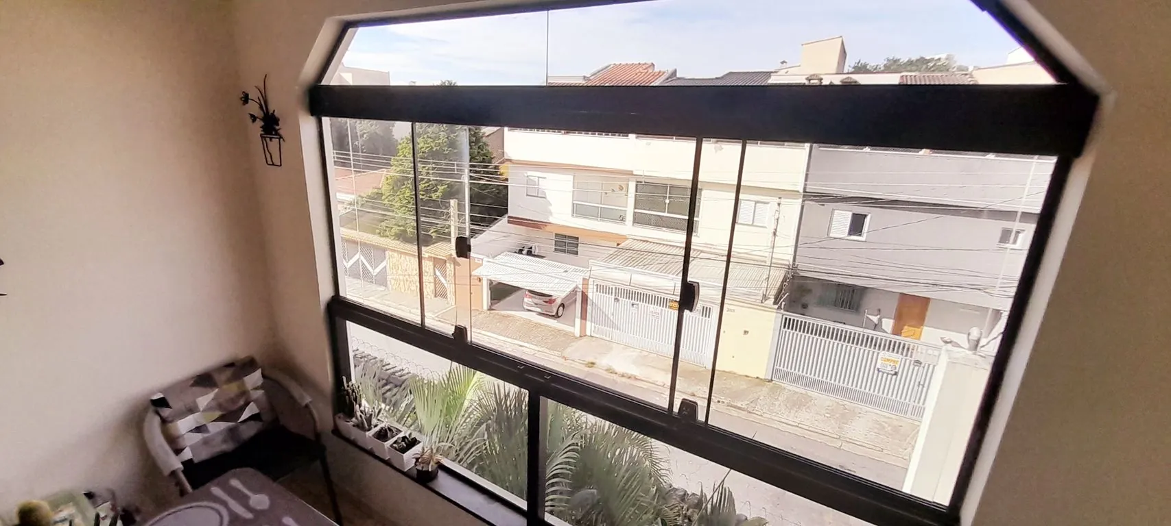 sacada envidraçada com vista privilegiada a rua principal